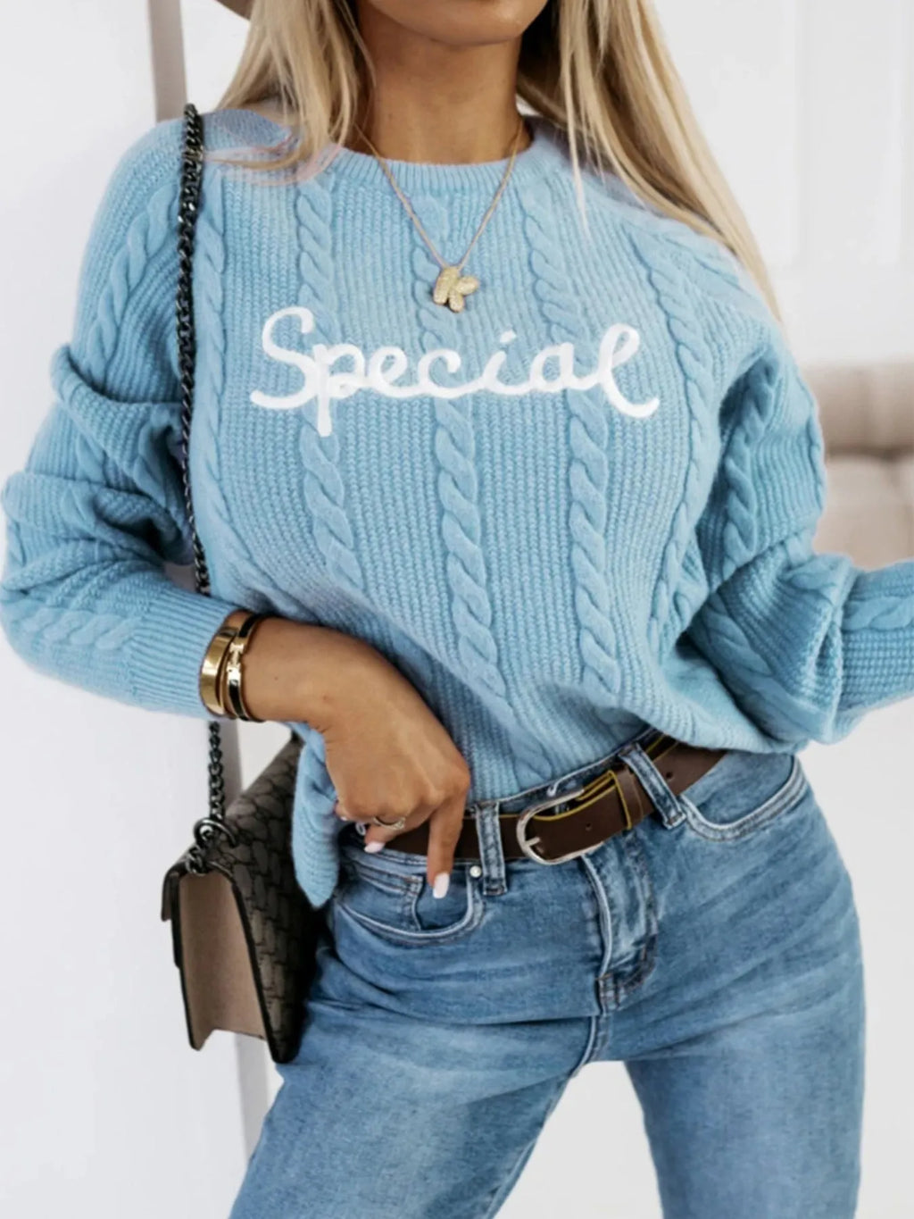 Blue crew neck pullover sweater with embroidered letters on the front, street fashion style.