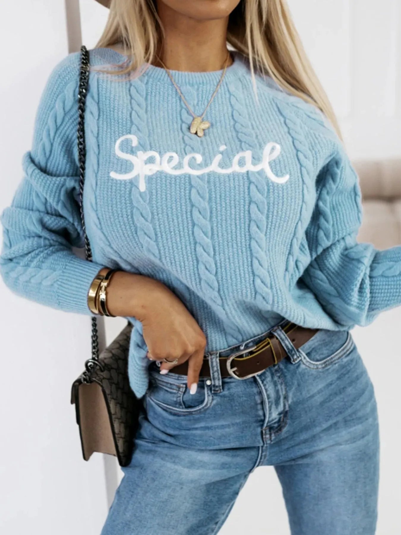 Blue crew neck pullover sweater with embroidered letters on the front, street fashion style.