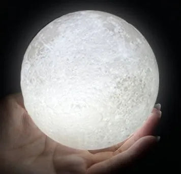 3D printed moon lamp glowing on a wooden stand with touch ring at base