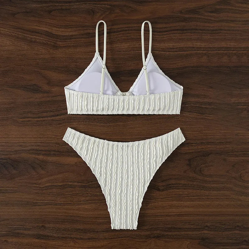 White women's V-neck sleeveless swimsuit with split design on a beach