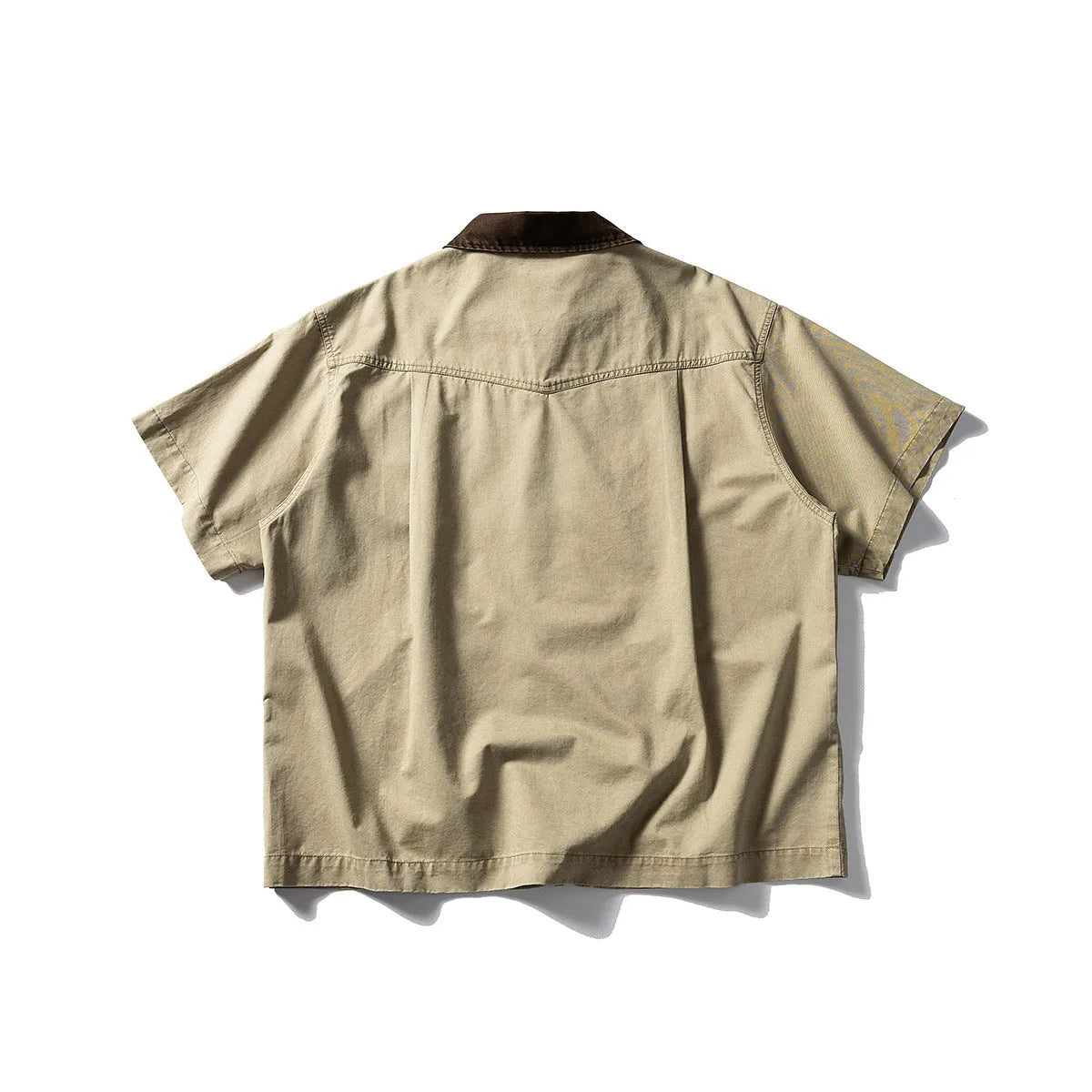 Loose grey short sleeve overalls shirt with cardigan front on a hanger.
