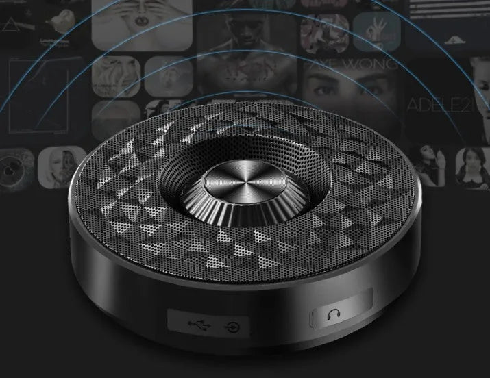 Compact black portable Bluetooth speaker on a table, showing its small size and design.