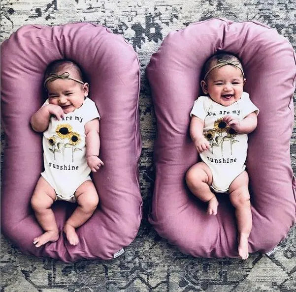 Beige portable cotton baby nest crib cushion for newborn infant sleep.