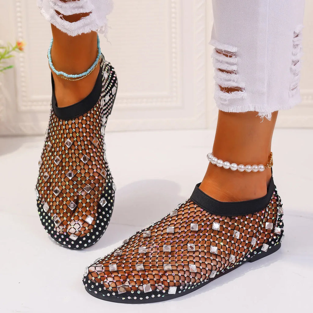 Women's flat sandals with colourful rhinestones on a mesh upper and a rubber sole.