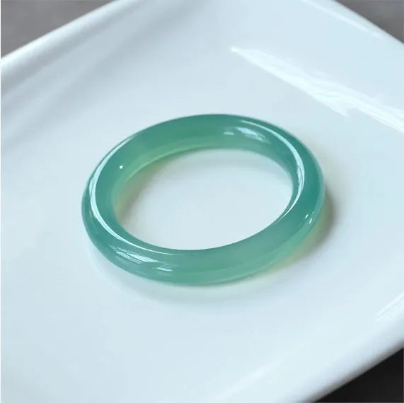 A natural agate wide tyre bracelet showing one of six colour options, such as pink or blue agate, on a wrist.
