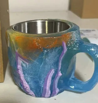 Purple and blue resin coffee mug with crystal texture and handle on wooden table