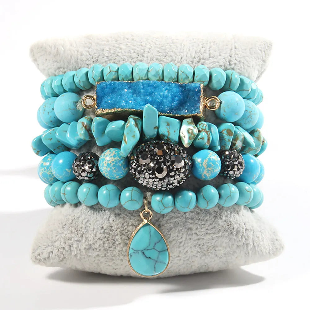 Set of five handmade stretch bracelets with glass, crystal, and hematite beads in irregular shapes on a neutral background