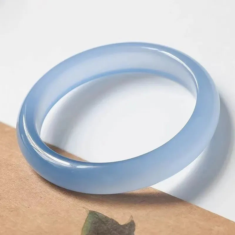 A natural agate wide tyre bracelet showing one of six colour options, such as pink or blue agate, on a wrist.