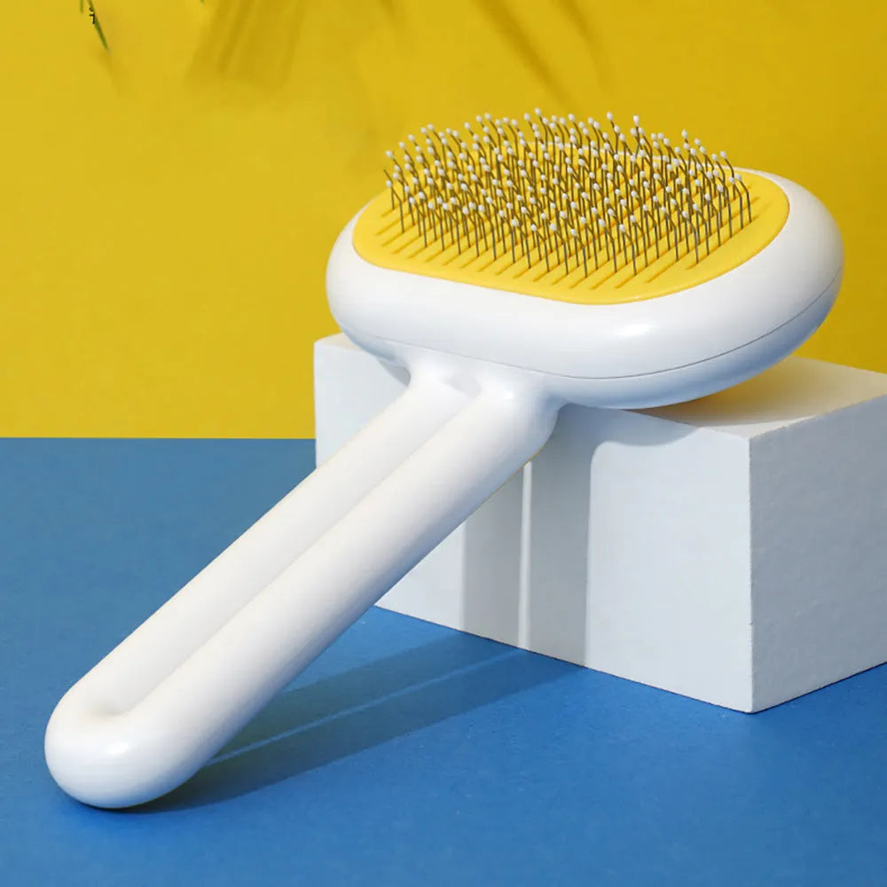 Cat dog grooming brush with stainless steel teeth and white silicone tips on a gray handle