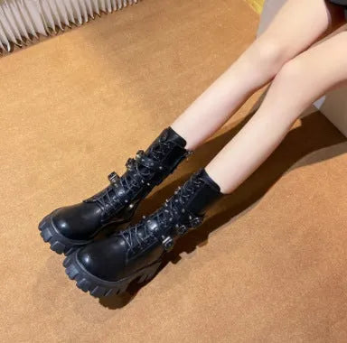 Women's black mid-calf knight boots with a metal buckle and side zipper on a chunky sole.