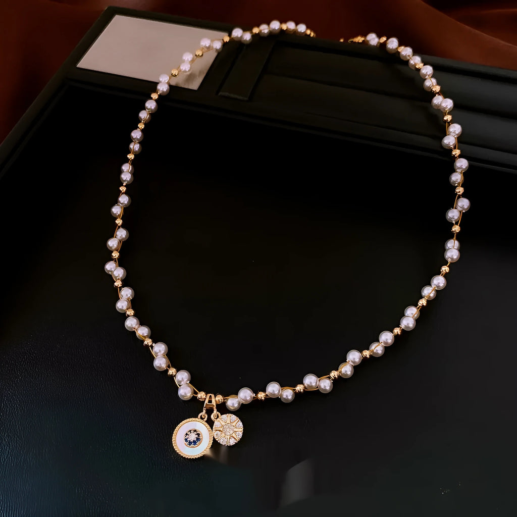 Gold electroplated necklace with zircon and imitation pearl pendant on an adjustable clavicle chain.