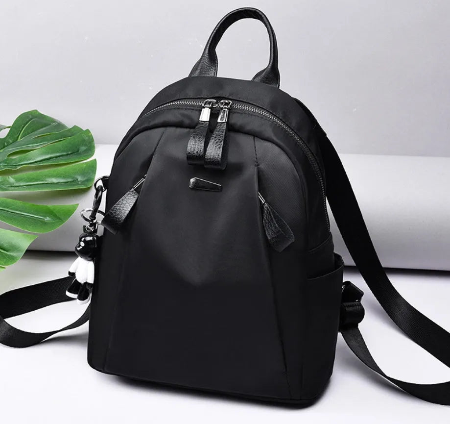 Medium square rucksack in Oxford cloth with dual straps, shown in grey colour with external digging bag.