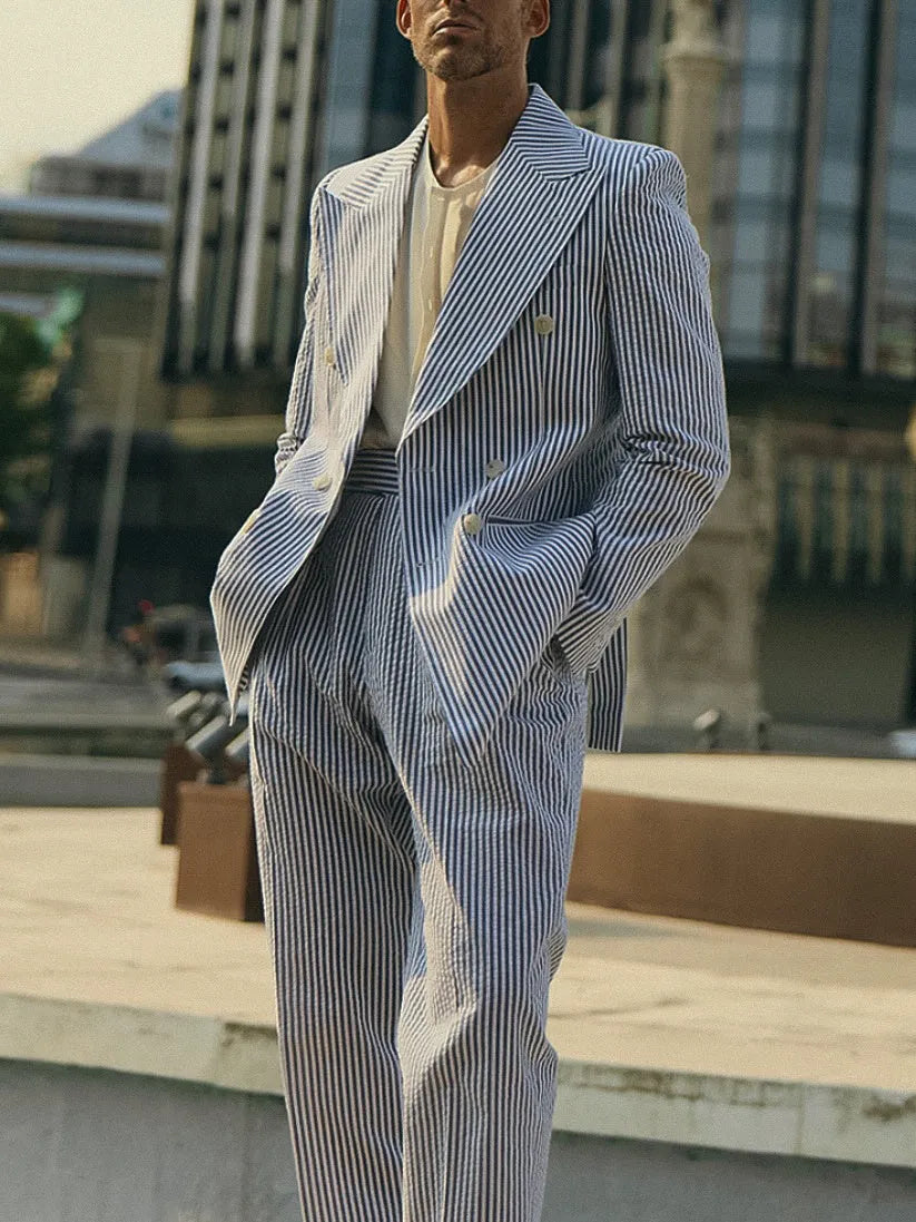 Blue and white striped polyester blazer and trousers suit set laid flat.