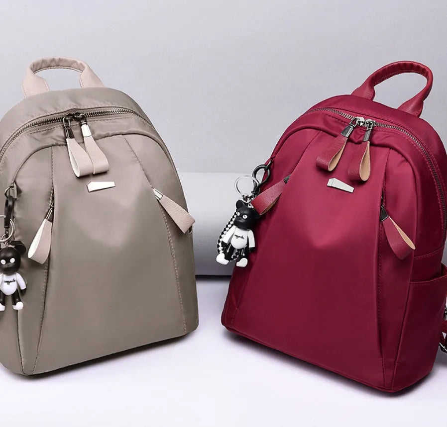 Medium square rucksack in Oxford cloth with dual straps, shown in grey colour with external digging bag.