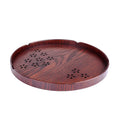 Twelve wooden dessert plates with carved cherry blossom design arranged in storage tray
