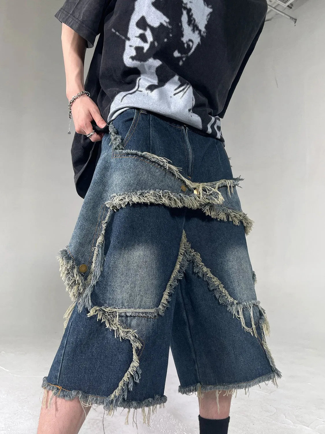 Blue cotton denim shorts for men with frayed hem detailing and five-pointed star patch, loose fit retro style