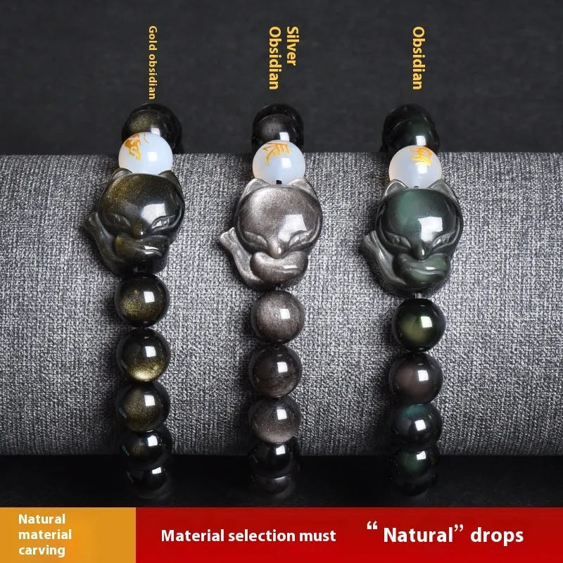 Natural black obsidian bracelet with 10mm beads on wrist, showing gold tone fastening option.