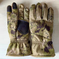 A pair of camouflage nylon ski gloves with touch screen fingertips on a winter background.