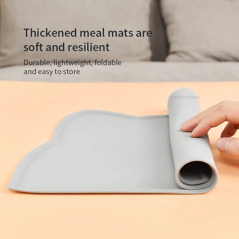 Blue waterproof silicone pet feeding mat for dog or cat bowls on a wooden floor.