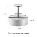 Silver stainless steel patty mould with 14cm diameter on a kitchen counter
