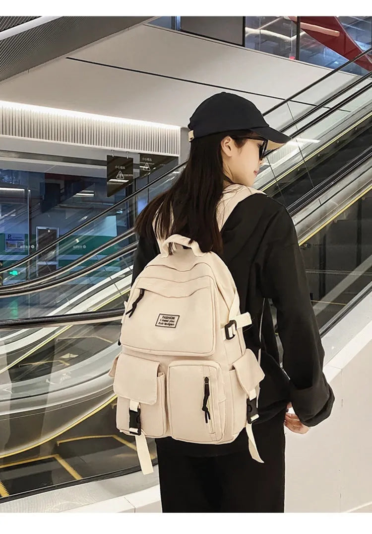 Black and white soft nylon student backpack showing external pockets and internal laptop compartment.