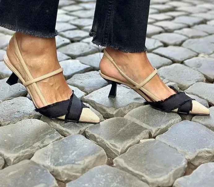 Women's apricot and black colour block pointed toe stiletto sandals with a buckle strap.