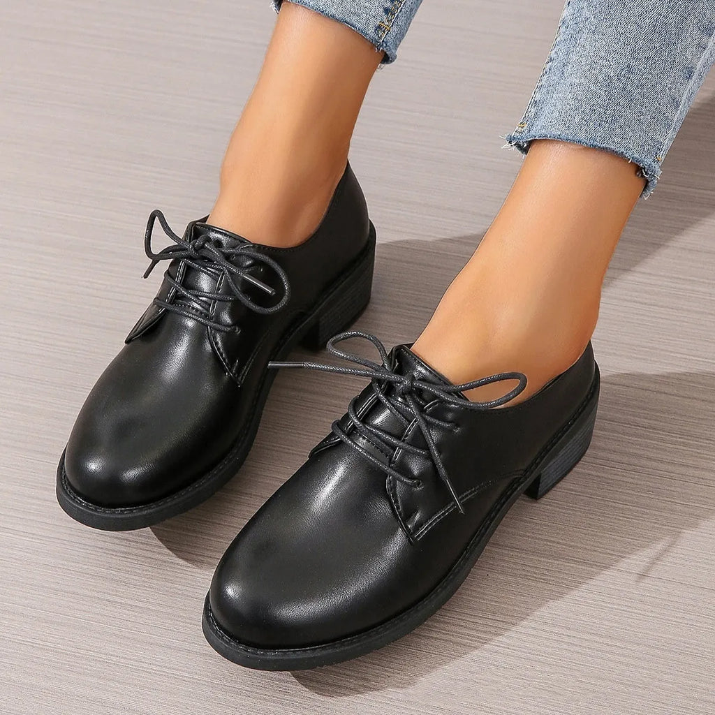 Black women's low-top work shoes with a thick chunky mid-heel and rubber sole.