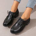 Black women's low-top work shoes with a thick chunky mid-heel and rubber sole.