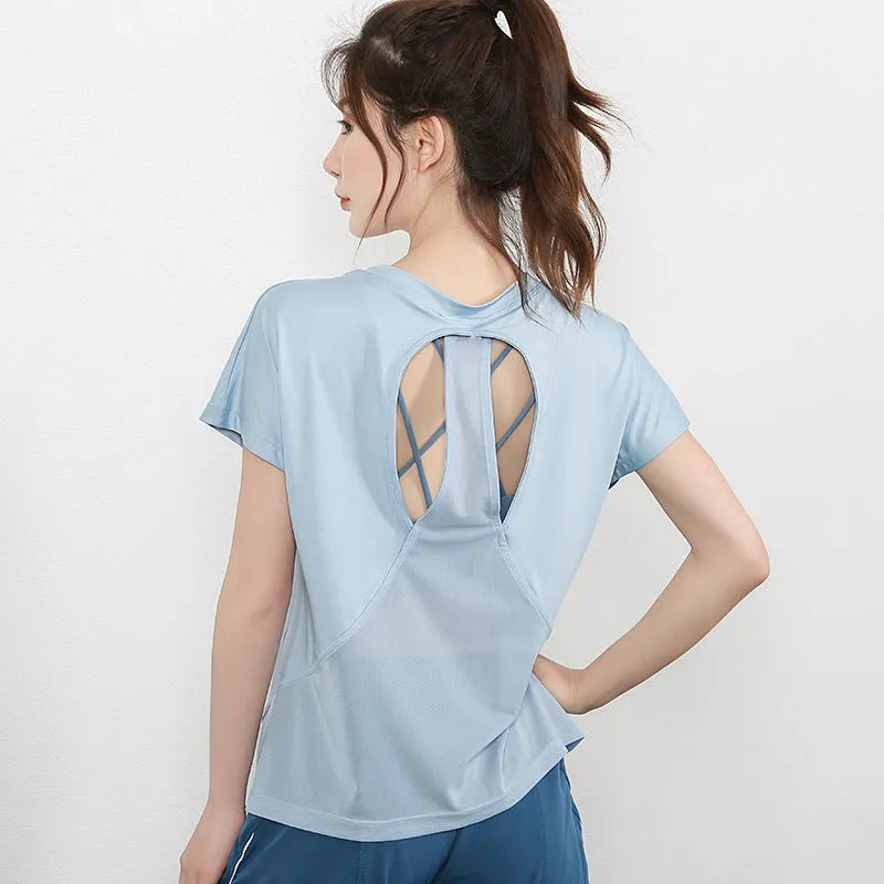 Women's short sleeve polyester sports t-shirt for yoga and running in pink, on a hanger.