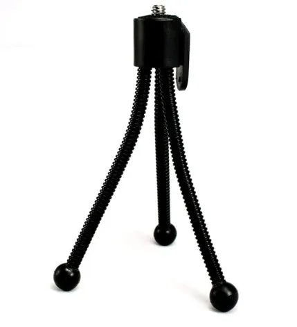 Small aluminium tripod with ball head collapsed to 110mm height next to mobile phone