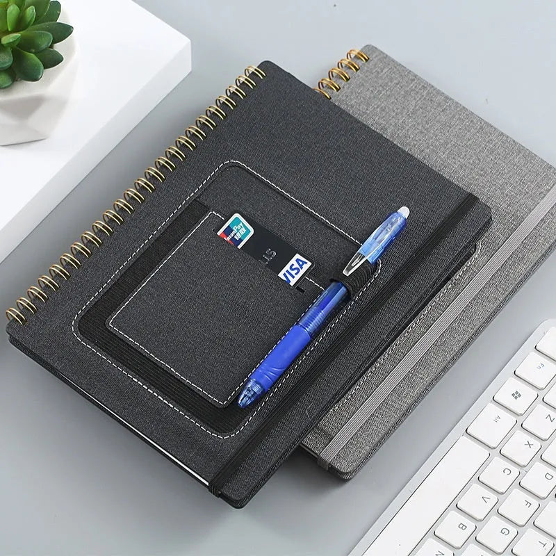 Erasable coil notebook with customisable cover options, shown with dedicated pen on stone paper.