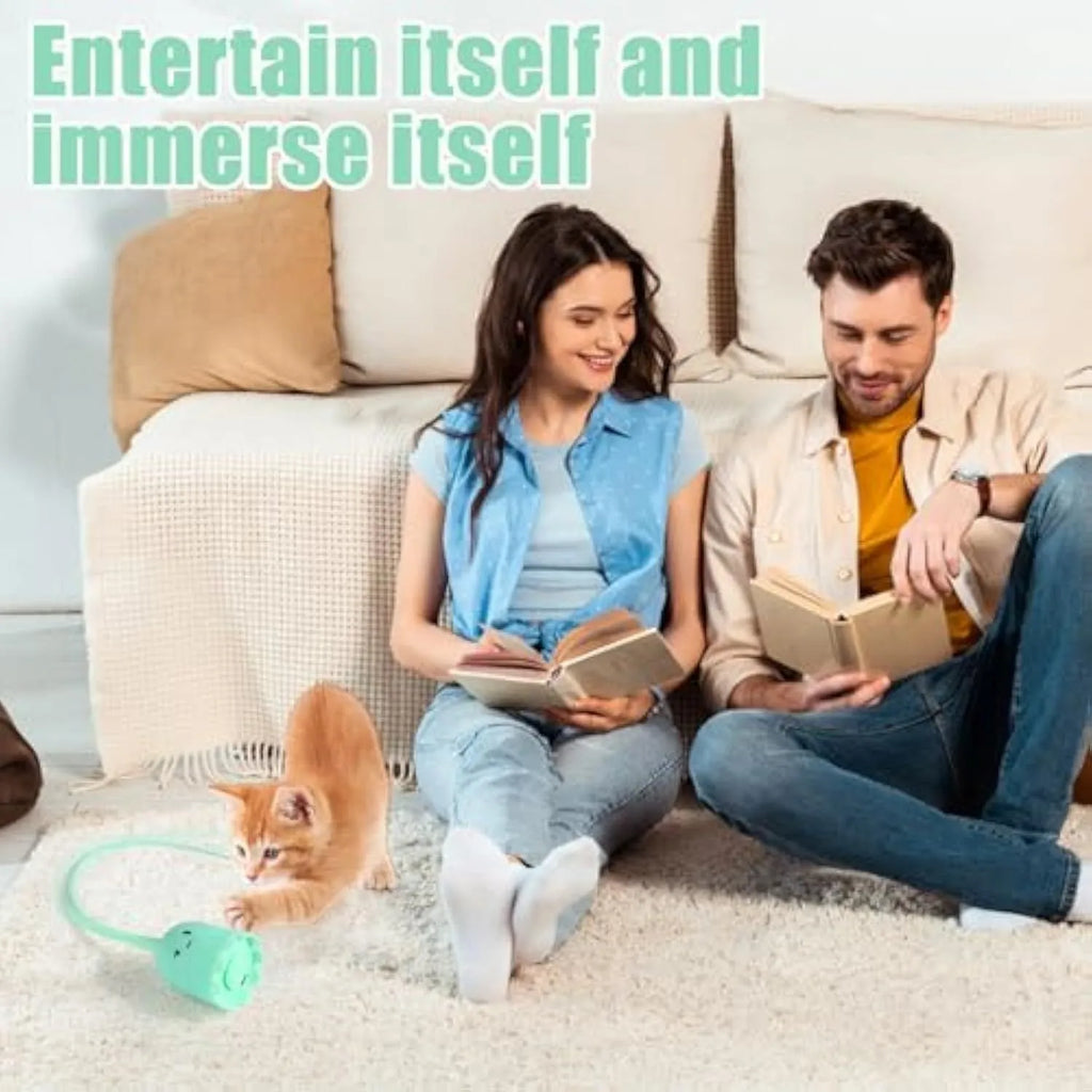 Green automatic cat wand toy with swinging silicone tail on floor for indoor cat play
