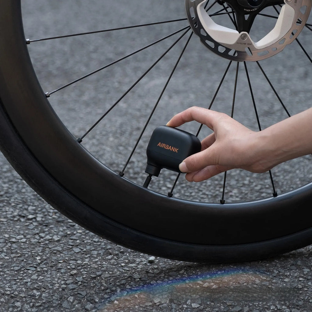 Black AS100 mini electric bicycle tyre pump with USB cable and waterproof storage bag.