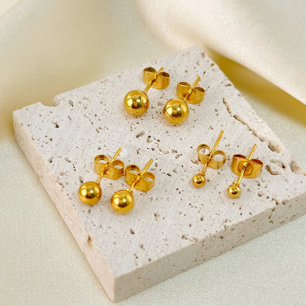 Stainless steel ball stud earrings in gold and silver tones showing 3mm to 6mm size variations