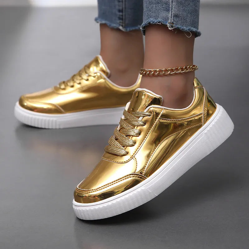 Gold sequinned platform sneakers with thick sole and round toe on a neutral background.