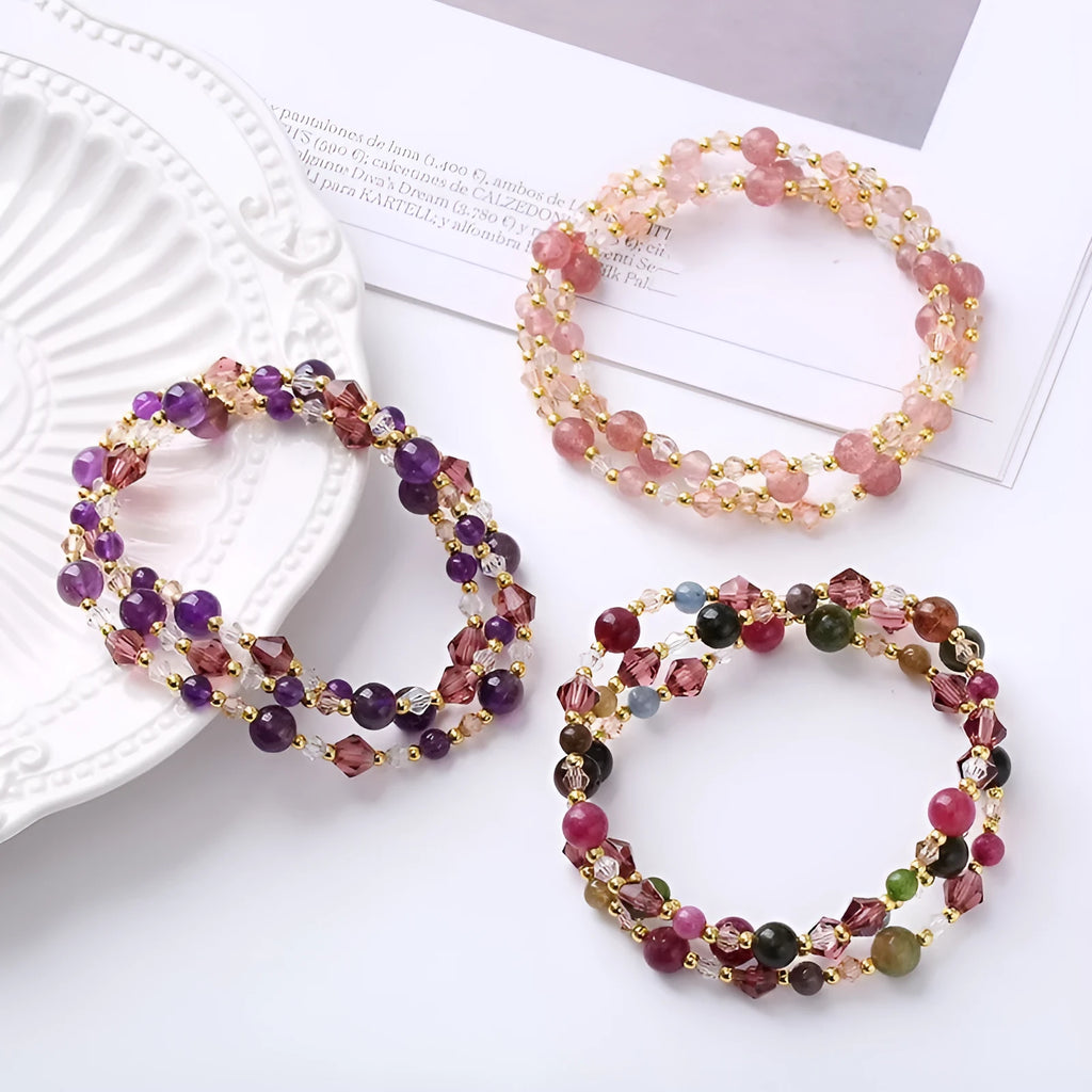 Women's handmade three-ring bracelet with tourmaline, strawberry quartz, and amethyst crystals on adjustable cord