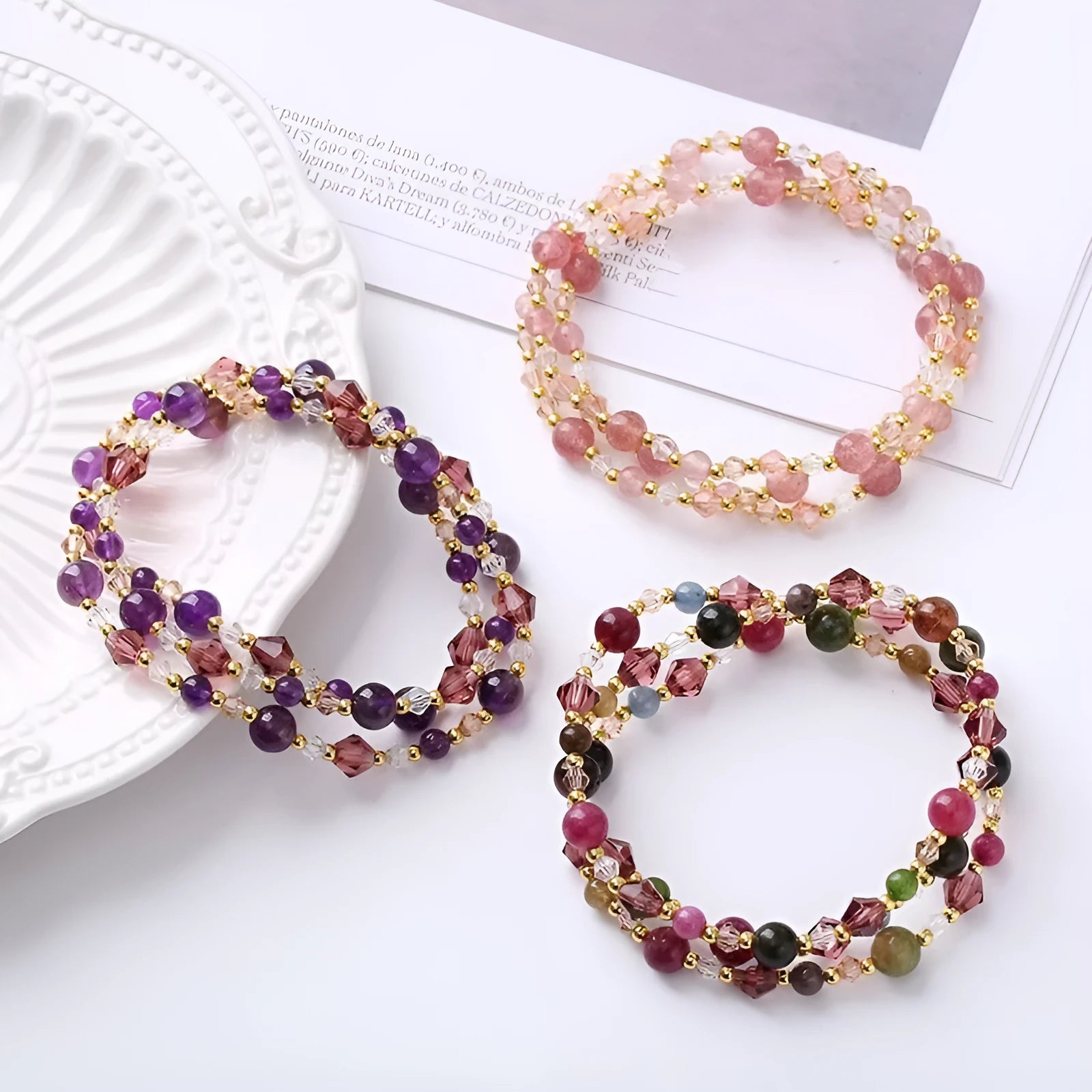 Women's handmade three-ring bracelet with tourmaline, strawberry quartz, and amethyst crystals on adjustable cord