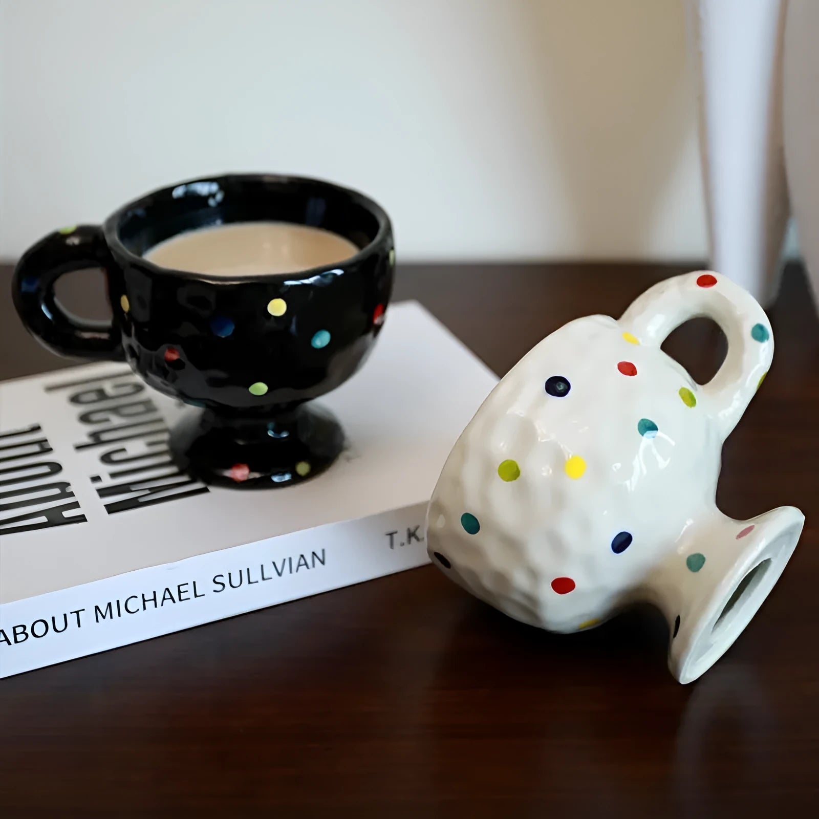 Hand-pinched irregular shaped ceramic mug in a solid colour, shown on a table.