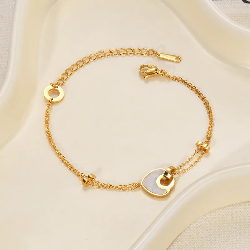 Women's stainless steel bracelet with double-layer design and a hanging heart charm in a resin-like electroplated finish.