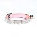 Close-up of a soft red velvet cat collar with a line of sparkling rhinestones and an adjustable buckle.