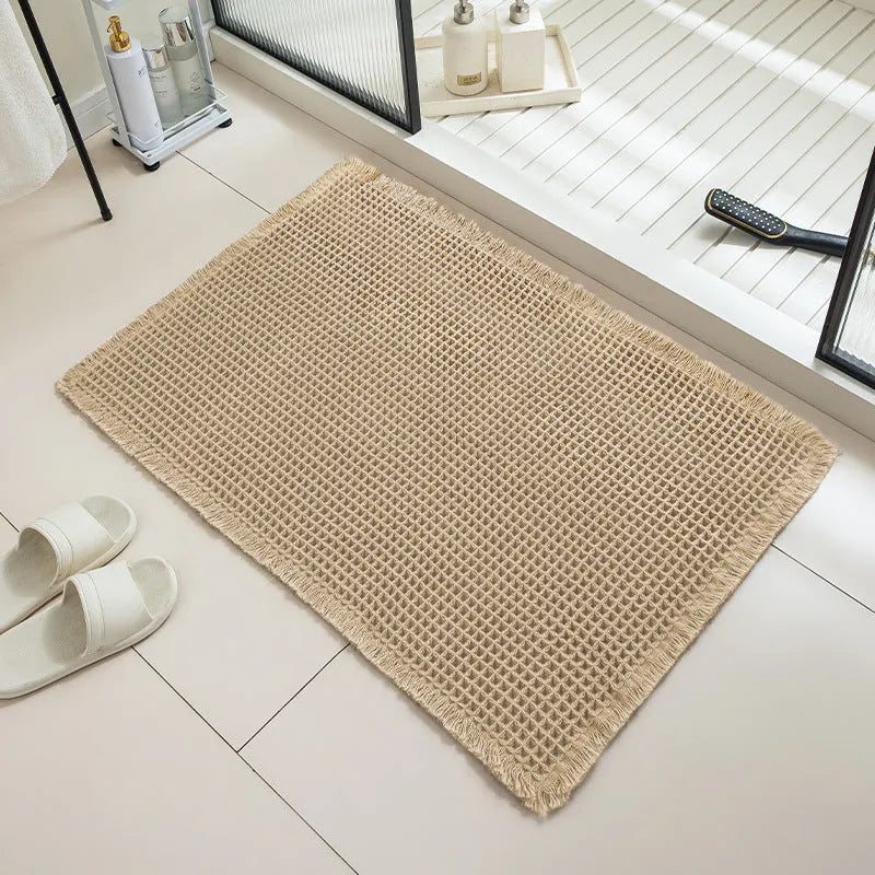 Square checkered pattern bathroom carpet on tiled floor in light grey colour.
