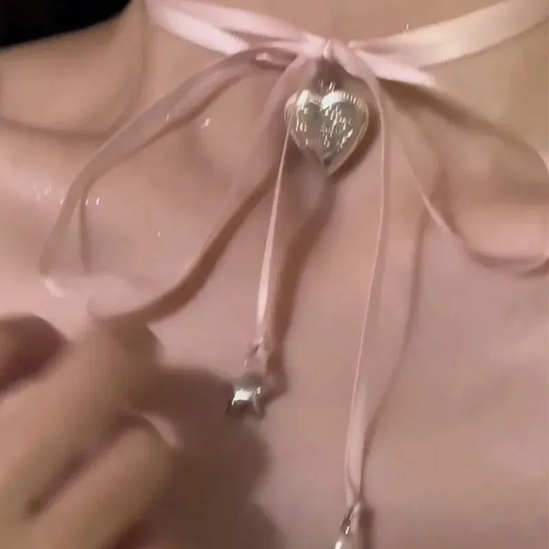 Women's ribbon love pendant fashion necklace in alloy with electroplated finish on clavicle chain.