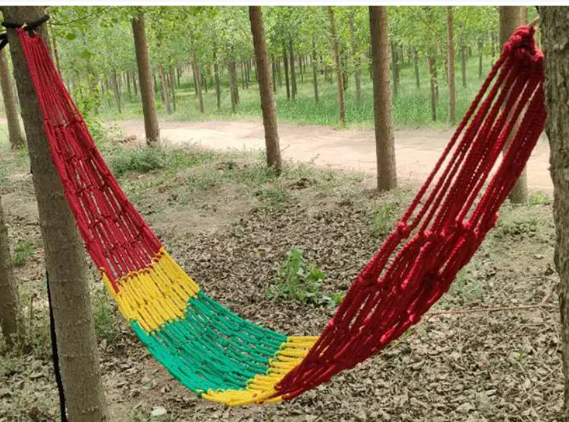 Outdoor nylon rope mesh hammock hanging between two trees showing mesh pattern and included tying ropes