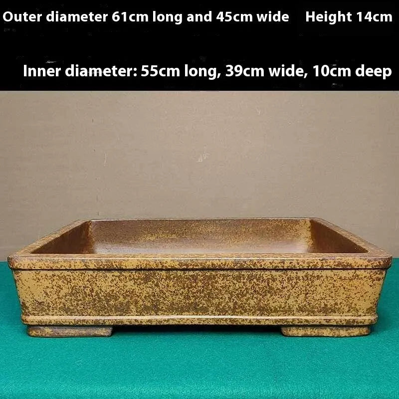 Straight shallow rectangular Yixing Zisha flowerpot in purple sand clay on a ground surface.