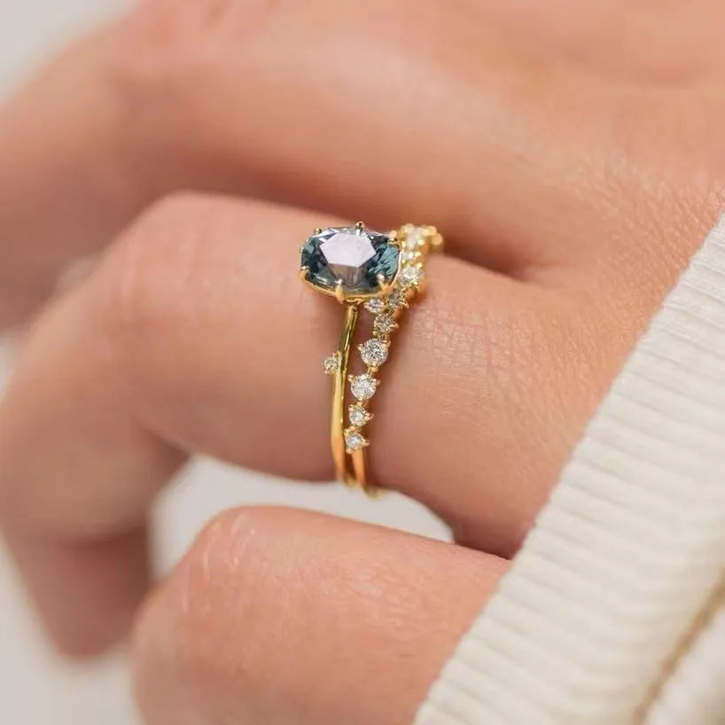 Gold plated floral women's ring with a central green zircon stone.