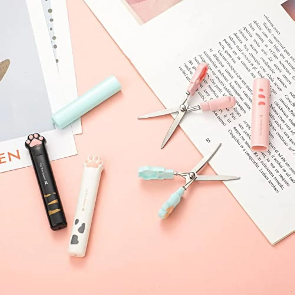 Set of four small folding scissors with cat paw handles in black, blue, pink, and white colours.