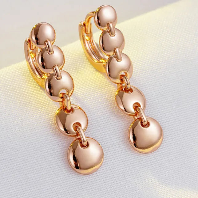 Long gold retro hoop earrings with woven copper texture, shown as a pair.