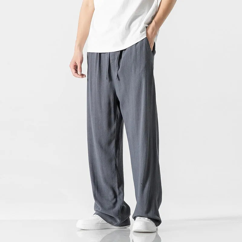 Men's beige bamboo fibre straight-leg cropped trousers with a drawstring waist on a neutral background.