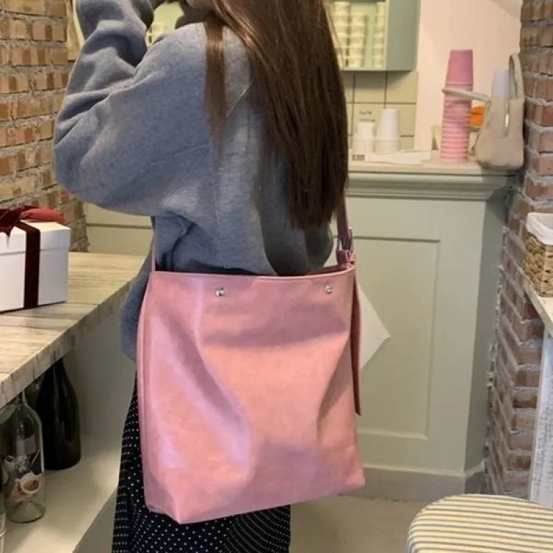 Corduroy single-shoulder commuter bag in pink with rectangular shape showing textured fabric