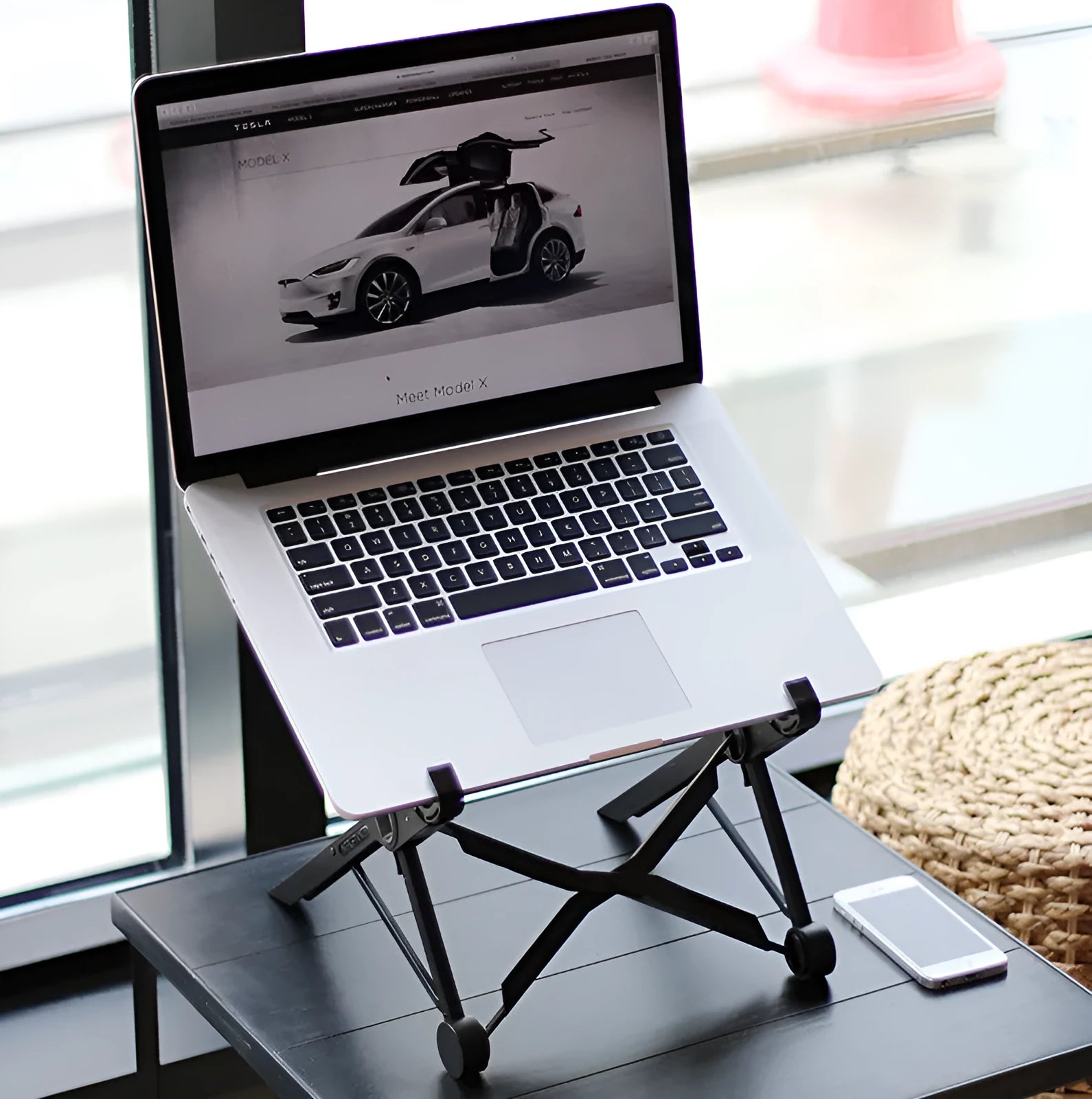 Black folding laptop stand with 360° rotating base shown in open and closed positions